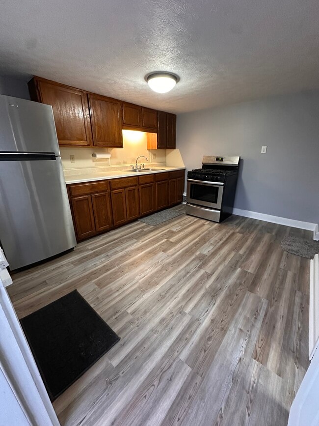 Kitchen with new luxury vinyl plank, beautiful gas stove and stainless refrigeratoro - 1841 E 5th St