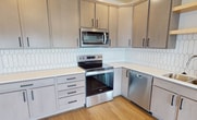 This contemporary 2-bedroom apartment in Fargo, North Dakota, offers 1020 square feet of well-designed living space. The interior is characterized by its bright and airy atmosphere, enhanced by large windows that flood the rooms with natural light and provide scenic views of the surrounding area.

The kitchen is a standout feature, boasting modern stainless steel appliances, including a side-by-side refrigerator with water dispenser, and ample cabinet space with sleek, light-colored finishes. A distinctive geometric tile backsplash adds visual interest, while the open layout seamlessly connects to the living area.

The living room is spacious and versatile, with hardwood flooring that extends throughout the main living areas. Large windows with adjustable blinds offer control over light and privacy. The bedrooms, including the 160 square foot primary bedroom, feature plush carpeting for comfort underfoot.

The apartment's design incorporates both open spaces and defined rooms, creating a balanced flow throughout. Built-in closets provide ample storage, and the neutral color palette allows for easy personalization. Recessed lighting and modern fixtures contribute to the overall contemporary aesthetic of this well-appointed Fargo residence.
