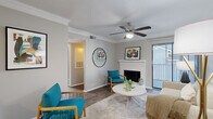 Located at 300 N Royal Oaks Blvd in Franklin, TN, this two-bedroom, two-bathroom single-floor residence offers a well-appointed layout designed for comfortable everyday living. The living room serves as the heart of the home, featuring a white brick fireplace, crown molding, a ceiling fan, and wood-style flooring. A sliding glass door opens to a private balcony, allowing natural light to fill the space and providing outdoor views. The galley-style kitchen is outfitted with white shaker cabinetry, quartz countertops, a subway tile backsplash, and stainless steel appliances including a range, microwave, refrigerator, and dishwasher. Both bedrooms are comfortably sized, each with ceiling fans and wood-style flooring. The primary bedroom offers a direct en-suite bathroom connection. The bathrooms feature white cabinetry, quartz countertops, and large vanity mirrors with modern fixtures. A dedicated laundry area houses an in-unit washer with overhead shelving for added storage. A hallway and closet round out the functional floorplan. Neutral gray tones and consistent finishes throughout give the home a cohesive, contemporary aesthetic.