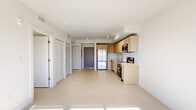 Located at 21580 Old Dixie Highway in Miami, FL, this two-bedroom, one-bathroom residence offers a clean, modern design within a thoughtfully arranged single-floor layout. The open-concept living area seamlessly integrates the kitchen, dining, and living spaces, creating an airy and functional environment. Light-toned tile flooring flows throughout the main area, complementing the bright white walls and contributing to an overall sense of openness.

The kitchen is outfitted with light maple shaker-style cabinetry, a white countertop, a stainless steel sink, and a full suite of stainless steel appliances including a range, over-the-range microwave, dishwasher, and refrigerator. Track lighting overhead adds both task and ambient illumination. A large sliding glass door at the end of the living space floods the room with natural light and provides views of the surrounding greenery.

The two bedrooms are well-proportioned, each featuring light tile flooring, white walls, and windows that frame views of mature trees. The primary bedroom includes a built-in closet. Additional storage is provided by three closets throughout the unit, along with a dedicated laundry area.

The bathroom features a vessel sink atop a wood-toned vanity with a white countertop, a full soaking tub with tile surround, and a large mirror — all finished in warm, neutral tones.