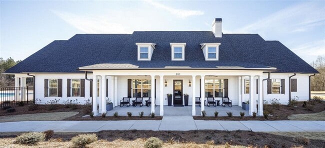 Clubhouse exterior with ample parking for future residents and visitors. - Cottages at Ridge Pointe