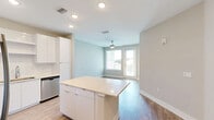 Located at 741 Clay St in Winter Park, FL, this one-bedroom, one-bathroom unit offers a well-designed layout with modern finishes throughout. The open-concept kitchen and living area serves as the heart of the home, featuring warm wood-tone cabinetry, a white tile backsplash, stainless steel appliances including a refrigerator, range, microwave, and dishwasher, and a central kitchen island with a neutral quartz-style countertop. Recessed lighting illuminates the space, while light wood-style flooring runs seamlessly through the main living areas, enhancing the bright and airy atmosphere. A ceiling fan in the living area adds both function and comfort. The bedroom is a well-proportioned retreat bathed in natural light from a large window with views of mature trees outside. A ceiling fan adds to the room's comfort, and the light flooring continues here as well. Three closets provide ample storage throughout the unit. The full bathroom is finished with a wood-tone vanity, stone-look countertop, a large mirror, and a full tub-shower combination with white tile surround. A dedicated laundry area rounds out the thoughtful and efficient layout of this contemporary Winter Park residence.