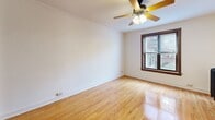 Located on N Cleveland Avenue in Chicago's sought-after Lincoln Park neighborhood, this one-bedroom, one-bathroom unit offers an efficient and thoughtfully arranged layout across a single floor. The main living area is bright and open, featuring warm hardwood floors that extend throughout the space, a ceiling fan with light fixture, and a window that brings in natural light and neighborhood views. The compact kitchen is neatly tucked into its own alcove and is equipped with rich dark wood cabinetry, granite countertops, a gas range, stainless steel microwave, and a full-size refrigerator — all framed by under-cabinet lighting that adds warmth to the space. The spacious bedroom continues the hardwood floor aesthetic and benefits from a large window with wood trim, offering ample natural light. A dedicated walk-in closet with dual hanging rods and built-in shelving provides generous storage. The bathroom retains classic Chicago character with a black-and-white basketweave tile floor, a cast-iron radiator, dark wood-framed door, tiled walls, and a tub-shower combination with a window above. This unit blends vintage charm with functional modern updates throughout.