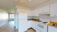 This well-organized 2-bedroom, 1-bathroom unit offers a functional and comfortable layout across a single floor. The combined kitchen and living area serves as the heart of the home, with the kitchen featuring white cabinetry, laminate countertops, white appliances including a refrigerator, electric range, and dishwasher, and light wood-style flooring that extends throughout the main living spaces. A ceiling fan and natural light from a large window brighten the open area, which also provides access to a balcony or patio space.

Both bedrooms are well-proportioned, each equipped with its own closet — one featuring mirrored sliding doors — and baseboard heating. The primary bedroom is carpeted and benefits from a dedicated closet with built-in shelving. The second bedroom similarly offers carpet flooring and a window for natural light.

The bathroom is cleanly appointed with a single vanity topped with a speckled countertop, a large mirror, a tub/shower combination, and tile flooring. Additional storage is provided by three closets throughout the unit, along with a dedicated utility room. Textured ceilings and neutral wall tones carry consistently through the space, creating a cohesive and move-in ready environment.