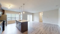 Located in Perry Hall, Maryland, this single-floor, 3-bedroom, 2-bathroom residence offers a thoughtfully designed layout that balances comfort and functionality. The open-concept kitchen and living area serves as the heart of the home, featuring light wood-look flooring, dark espresso cabinetry, granite countertops, a central island with pendant lighting, a tile backsplash, and stainless steel appliances. A large window floods the kitchen with natural light, while sliding glass doors in the living room provide outdoor views and additional brightness.

The three bedrooms are finished with plush wall-to-wall carpeting and neutral-toned walls, creating a calm, inviting atmosphere. The spacious primary bedroom includes a generous walk-in closet with wire shelving and a natural light-filled window. The two bathrooms are finished with tile flooring; the primary bath features a tiled walk-in shower with glass sliding doors.

A dedicated laundry room houses a full-size washer and dryer set atop tile flooring, adding everyday convenience. A connecting hallway ties all rooms together seamlessly. Throughout the home, clean white trim, consistent neutral tones, and carefully chosen finishes create a cohesive, modern aesthetic well-suited for comfortable living.