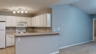Located at 5500 Faith Dr in Fayetteville, NC, this single-story home offers a well-organized layout across multiple interconnected living spaces. The living room serves as a central highlight, featuring soaring vaulted ceilings and a ceiling fan that enhance the sense of openness. A fireplace with a white mantel anchors the room, while soft carpet flooring runs throughout. This space flows naturally into a dining area, which is illuminated by a classic chandelier and benefits from natural light through a window overlooking the outdoors.

The kitchen is designed for functionality, equipped with white raised-panel cabinetry, a coil electric range, built-in microwave, dishwasher, and light countertops. Tile flooring runs through the kitchen, which connects to the living area via a peninsula breakfast bar, creating an open and convenient layout.

Bedrooms are carpeted and include ceiling fans with light fixtures and windows that bring in natural light. The primary bathroom features a soaking tub, single vanity with storage cabinetry, and tile flooring. A secondary full bathroom mirrors a clean, practical design with a tub/shower combination, single vanity, and matching tile floors. Throughout the home, neutral gray walls and white trim create a consistent, understated aesthetic.