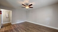 Located at 4010 Linkwood Dr in Houston, TX, this single-story home offers a practical and well-organized layout across a comfortable footprint. The living room welcomes you with rich, dark wood-look flooring, neutral gray walls, crisp white baseboards, and a ceiling fan with a light fixture — a combination that repeats throughout the main living areas, creating a cohesive, clean aesthetic. Natural light filters in through multiple windows fitted with blinds, brightening the open feel of the space. The living area flows into a dedicated dining room, making the layout convenient for everyday living and entertaining. The kitchen is equipped with stainless steel appliances and is complemented by a pantry, offering practical storage. The primary bedroom is a generously sized retreat featuring plush carpet, a ceiling fan, a window with natural light, and access to a dedicated closet. The bathroom is well-appointed with a granite-topped vanity featuring dark wood cabinetry, a tub-shower combination with subway tile surround, and wood-look flooring. Additional highlights include four closets distributed throughout, a hallway connecting the rooms, and an efficient single-floor plan that maximizes usability. The overall ambiance is clean, modern, and move-in ready.