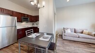 Located at 2830 Cozy Court in Evansville, Indiana, this single-floor unit is part of a multi-unit building and offers a thoughtfully designed, efficiently utilized layout. Wood-look plank flooring runs throughout, providing a warm, cohesive aesthetic across all areas.

The kitchen is equipped with rich, dark-toned cabinetry, light countertops, and a full suite of stainless steel appliances, including a refrigerator, microwave, and dishwasher. An adjacent dining area accommodates a small table and benefits from an overhead chandelier, while the open sightline connects seamlessly to the living space.

The living area features neutral walls, recessed lighting, and a window that allows natural light to filter in, creating a calm and functional setting. A dedicated bathroom includes an accessible walk-in shower with grab bars and a stacked washer and dryer unit tucked neatly into a closet, providing convenient in-unit laundry. An additional open area offers flexible use with open wall space and wood-look flooring consistent with the rest of the unit. The overall design emphasizes clean lines, modern fixtures, and practical use of the available footprint.