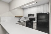 This 520 square foot apartment in Nashville, TN offers a thoughtful layout maximizing space and functionality. The single-floor unit comprises one bedroom, one bathroom, and an open-concept kitchen and living area. The primary bedroom, measuring 160 square feet, features plush carpeting and a window allowing natural light. The living area boasts wood-look flooring and a large window, creating a bright, airy atmosphere. The kitchen, while compact, is efficiently designed with white cabinetry, subway tile backsplash, and granite countertops. Modern appliances enhance its functionality. The bathroom showcases elegant marble-look tiling and a white bathtub. Throughout the apartment, neutral wall colors provide a canvas for personalization. A ceiling fan in the living area aids in air circulation. The property's design emphasizes natural light with multiple windows offering views of the surrounding greenery, contributing to a fresh and inviting living space.
