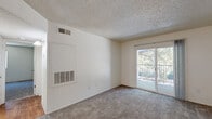 Located at 4350 Galbraith Dr in Sacramento, CA, this two-bedroom, one-bathroom unit offers a practical and well-organized single-floor layout. The kitchen features warm wood-toned cabinetry, light countertops, a double sink, and black appliances including a range, overhead microwave, and refrigerator, all set atop durable wood-style flooring that adds warmth to the space. The living area is carpeted and bathed in natural light from a sliding glass door that opens to a private balcony overlooking lush greenery, providing a pleasant outdoor connection. Both bedrooms are finished with plush carpet and textured ceilings. The primary bedroom is a comfortable size and includes a sliding-door closet, while the second bedroom also offers closet access and a window with vertical blinds that allow for adjustable natural light. The shared full bathroom features tile flooring, a wood-cabinet vanity with a light countertop, a wall-mounted mirror, and a shower-tub combination. Throughout the unit, neutral wall tones and consistent finishes create a clean, cohesive aesthetic. Central HVAC vents are present in multiple rooms, ensuring year-round climate comfort across the entire home.