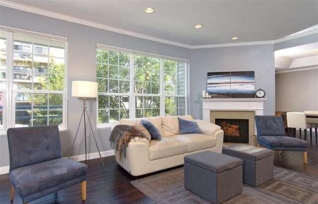 Living room with fireplace and large windows overlooking serene Wilkins Ave - 10640 Wilkins Ave