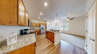 This well-appointed 2-bedroom, 2-bathroom residence in Greeley, Colorado offers a thoughtfully designed single-floor layout with a seamless blend of function and comfort. The open-concept kitchen serves as the centerpiece of the home, showcasing warm knotty alder cabinetry, light granite countertops, a central island with pendant lighting overhead, and a full suite of stainless steel appliances including a French door refrigerator, electric range with microwave, and dishwasher. Recessed lighting and wood-look plank flooring extend throughout the kitchen and main living areas, creating a cohesive, modern feel.

The living area flows naturally from the kitchen and is brightened by large windows and a sliding glass door that invite natural light. A ceiling fan adds practical comfort to the space. Both bedrooms are carpeted and generously sized, with the primary bedroom featuring dual windows, a ceiling fan, and ample natural light. The second bedroom includes a sliding closet with built-in shelving.

The two bathrooms are finished with wood-tone cabinetry and wood-look flooring. One bathroom offers a full tub/shower combo, while the other features an extended vanity with a tall storage tower and large mirror. A connecting hallway ties the layout together efficiently.