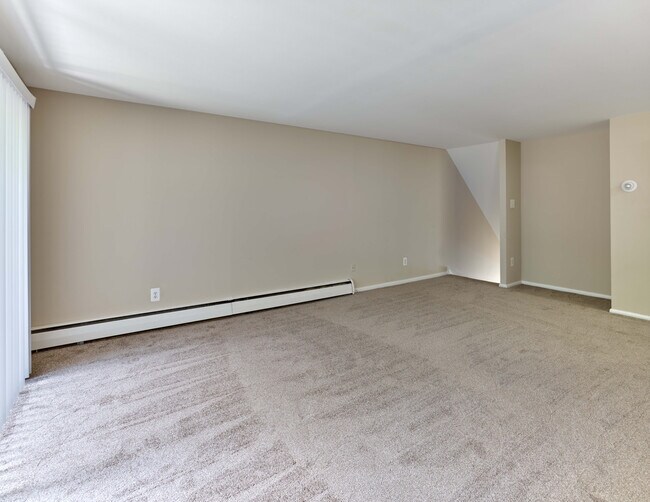 Amplia sala de estar con alfombra de felpa y diseño abierto en Maple Terrace Apartments en Maple Shade, NJ - Maple Terrace
