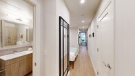 Located at 3220 Prospect St NW in Washington, DC's prestigious Georgetown neighborhood, this efficiently designed one-bedroom, one-bathroom residence makes excellent use of its intimate footprint. Light wood flooring runs throughout, lending warmth and visual continuity across the single-floor layout.

The kitchen is a standout feature, outfitted with light wood cabinetry extending to the ceiling, white quartz countertops, a gray subway tile backsplash, and a full suite of stainless steel appliances including a refrigerator, dishwasher, range, and built-in microwave. A compact dining area sits adjacent, maximizing the functionality of the space.

A bright, welcoming hallway connects the main living areas to the private bedroom, which is separated by a striking black-framed glass partition door that adds a modern, architectural touch. The bedroom is cozy and well-proportioned, offering a comfortable retreat.

The bathroom is finished with large-format tile flooring, warm wood-toned cabinetry, a white undermount sink with a framed vanity mirror, and a full soaking tub with shower. Recessed lighting throughout the unit keeps the interiors bright and inviting. This well-appointed residence offers a polished, modern living experience in one of DC's most sought-after neighborhoods.
