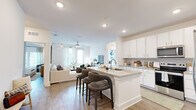 Located at 3730 Dupont Avenue in Jacksonville, FL, this thoughtfully designed 2-bedroom, 3-bathroom residence offers a bright and modern living experience across a single floor. The open-concept layout connects the kitchen and living room seamlessly, creating an inviting communal space. The kitchen is outfitted with crisp white cabinetry, granite countertops, stainless steel appliances, and a central island with bar seating — ideal for casual dining and entertaining. Wood-style flooring runs throughout the main areas, complementing the clean, contemporary aesthetic. The living room is bathed in natural light from large windows and a glass door, with ceiling fans adding comfort. Both bedrooms are generously proportioned, featuring large windows with sheer draping, ceiling fans, and ample closet space. The primary bedroom is accompanied by a well-appointed en-suite bathroom with a double vanity featuring granite countertops, a glass-enclosed walk-in shower, and hardwood-style flooring. A dedicated laundry room houses a full-size washer and dryer with overhead shelving. Two walk-in closets with wire shelving systems provide excellent storage. With three full bathrooms, two closets, and a hallway connecting all spaces efficiently, this residence delivers both functionality and refined comfort.