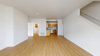 Located at 2 River Chase Dr. in Rensselaer, NY, this two-story home offers a well-designed layout spread across two floors. The main level features an open-concept living room and kitchen area with warm light wood-style flooring throughout. The kitchen is equipped with stainless steel appliances, including a refrigerator, dishwasher, and range, complemented by warm-toned wood cabinetry and a central island. A full bathroom with a walk-in shower and wood cabinetry is also found on the main floor, along with a convenient in-unit laundry room housing a full-size washer and dryer. The main level is completed by an attached garage with an automatic opener, providing practical everyday access. Upstairs, two carpeted bedrooms offer a comfortable retreat, each featuring ample closet space with double panel doors. The spacious primary bedroom receives natural light through a large window with views of the surrounding greenery. A second full bathroom serves the upper level. With five closets throughout, clean white walls, and a neutral palette, this home presents a bright, move-in-ready living environment in a residential Rensselaer neighborhood.
