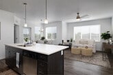 Located at 11922 W Fairview Ave in Boise, Idaho, this single-floor residence showcases a clean, contemporary design characterized by a neutral palette, light wood-style flooring, and an abundance of natural light throughout. The open-concept living area seamlessly connects the kitchen, dining, and living spaces, creating a cohesive and functional flow. Large windows fitted with horizontal blinds allow ample daylight to fill the space, while a ceiling fan overhead adds practical comfort to the living room.

The kitchen is a standout feature, equipped with dark wood cabinetry extending to the ceiling, stainless steel appliances, recessed lighting, and a generously sized island with a white quartz countertop and bar seating for multiple guests. Pendant lights above the island add a refined touch. Adjacent to the kitchen, the dining area accommodates a full table beneath a chandelier, surrounded by windows offering neighborhood views.

The bedrooms are carpeted for warmth and comfort, featuring multiple windows and ample closet space. The bathroom presents dark wood vanity cabinetry, a large mirror, white countertops, and wood-style flooring. A dedicated in-unit laundry area houses a full-sized washer and dryer with overhead shelving, adding everyday convenience to this well-appointed Boise residence.