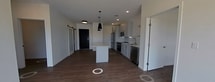 This contemporary 950 square foot home in Bismarck, North Dakota, offers a harmonious blend of functionality and style. The single-story layout comprises two bedrooms, including a spacious 140 square foot primary bedroom, and two full bathrooms. The heart of the home is an open-concept living area that seamlessly integrates the kitchen and living room. The kitchen boasts modern white cabinetry, stainless steel appliances, and a central island, perfect for casual dining or entertaining. Large windows throughout flood the space with natural light and provide picturesque views of the surrounding neighborhood. The home features durable and attractive wood-look flooring throughout, creating a cohesive and low-maintenance interior. A dedicated laundry room adds convenience to daily living. The bathrooms are outfitted with sleek fixtures and ample storage. Closet space is thoughtfully incorporated, including a walk-in closet in the primary bedroom. Recessed lighting and pendant fixtures provide layered illumination, enhancing the modern aesthetic. This efficient and well-designed home offers comfortable living in a desirable Bismarck location.
