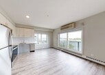 Located at 11025 26 Avenue NW in Edmonton, Alberta, this well-appointed 2-bedroom, 2-bathroom unit offers a thoughtfully designed single-floor layout. Light wood-look flooring flows throughout the space, complementing a neutral, contemporary color palette of soft whites and warm greiges.

The open kitchen features crisp white cabinetry, a classic subway tile backsplash, stainless steel appliances including a refrigerator, electric range, and built-in microwave, along with a dishwasher. Large windows flood the adjacent living area with natural light, while a sliding glass door provides access to a private balcony with open outdoor views.

Both bedrooms are comfortably proportioned, each with windows that invite natural light and baseboard heating. The primary bedroom includes a dedicated closet for convenient storage. A hallway with modern sliding doors connects the bedrooms to the two bathrooms, each finished with elegant marble-patterned wall surrounds. One bathroom features a walk-in glass-enclosed shower, while the other offers a full soaker tub — both appointed with polished chrome fixtures and light-toned flooring. The overall design is clean, modern, and move-in ready.