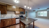 Located at 3825 Cedar Grove Pkwy in Eagan, MN, this well-appointed 2-bedroom, 2-bathroom residence offers a thoughtfully designed single-floor layout with generous living space. The open-concept kitchen and living area serves as the heart of the home, showcasing rich warm-toned cabinetry, dark granite countertops, stainless steel appliances including a refrigerator, range, microwave, and dishwasher, and a central island with pendant lighting overhead. Crown molding adds a refined architectural touch throughout. Hardwood-style flooring in the kitchen and entryway transitions seamlessly to plush carpet in the living and bedroom areas. Both bedrooms are well-sized, filled with natural light from large windows, and feature neutral taupe walls with clean white trim. The spacious primary bedroom offers a comfortable retreat with its own closet. The two bathrooms are finished with stone-look tile flooring, warm wood vanities with dark countertops, and a tub/shower combination. Additional features include a dedicated laundry area, a utility room, ample closet storage, and a private balcony. The overall ambiance is warm, neutral, and move-in ready.