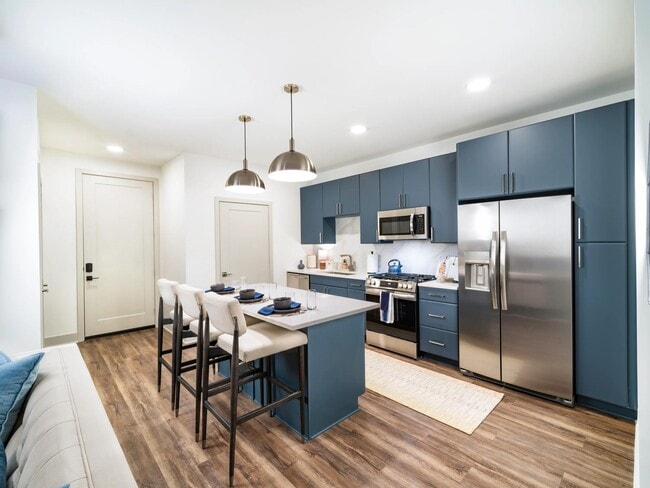 A spacious kitchen with a central island, full-size appliances, and streamlined cabinetry offers an additional finish option, designed to support your individualized daily routine. - Modera Westside Trail Apartments