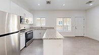 Located at 622 N 9th Ave in Phoenix, AZ, this third-floor unit offers a thoughtfully designed one-bedroom, one-bathroom layout with a clean, modern aesthetic throughout. Light-toned wood-style flooring runs continuously across the space, complementing the crisp white walls that create a bright, open atmosphere.

The kitchen serves as a central highlight, featuring white shaker cabinetry, granite countertops, a peninsula island for additional prep space, and a full suite of stainless steel appliances including a refrigerator, electric range, and built-in microwave. Recessed lighting and windows allow natural light to fill the space. A stacked in-unit washer and dryer adds everyday convenience.

The living area is open and airy, with neutral walls and ample room to arrange furnishings comfortably. The bedroom offers a window with views of the surrounding Phoenix neighborhood, fitted with blinds for privacy, and is serviced by a ceiling vent for climate control.

The bathroom is finished with a white subway-tiled walk-in shower, wood-look flooring, a granite-topped vanity with an undermount sink, and brushed gold fixtures that add a refined touch. A small window provides natural ventilation. This unit delivers a modern, functional living experience in a well-appointed setting.