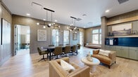 Located at 2920 Frontage Rd in Gainesville, GA, this thoughtfully designed single-floor space offers a refined blend of modern aesthetics and warm, natural materials. The layout includes two living areas and a private office, creating a versatile environment suited for both collaboration and focused work.

The main living areas are anchored by wide-plank light hardwood flooring and distinctive vertical shiplap wall paneling in a warm gray-taupe tone, lending a sophisticated yet approachable character throughout. A large oval conference table surrounded by cushioned leather chairs sits beneath striking black sculptural pendant light fixtures, while a separate lounge area features cognac leather sofas and a rounded white accent table, ideal for casual gatherings. Floor-to-ceiling windows flood the space with abundant natural light and offer views of the surrounding wooded landscape.

The private office is accessed through a full-glass door framed in black, maintaining an open and airy feel while providing acoustic separation. Inside, a patterned area rug grounds a sleek wooden desk positioned beneath tall windows that frame natural tree views, creating an inspiring and productive work environment. Curated artwork is displayed throughout, adding personality and visual interest. The overall ambiance is polished and cohesive, combining contemporary design with natural warmth.