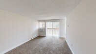 This well-appointed one-bedroom, one-bathroom residence at 150 Ridgefield Dr in Middletown, CT offers a practical and comfortable layout across a single floor. The living room is a bright, open space featuring plush wall-to-wall carpeting, a textured ceiling, baseboard heating, and a wall-mounted air conditioning unit. Sliding glass doors lead to a private balcony overlooking wooded surroundings, filling the room with natural light. A secondary window further enhances ventilation and brightness.

The kitchen is a functional highlight of the home, showcasing white shaker-style cabinetry, dark granite-style countertops, and a full suite of stainless steel appliances including a range, microwave, dishwasher, and refrigerator. Light tile flooring and a window overlooking the outdoors complete the space.

The bedroom is comfortably sized, featuring soft carpeting, a window with natural light, and baseboard heating. A closet provides dedicated storage. The bathroom is clean and well-maintained, offering a full tub-shower combination, a white vanity with mirror and lighted fixture, and tile flooring. Neutral tones and white trim throughout the residence create a cohesive and move-in ready aesthetic.