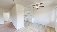 Located at 5151 Woodman Ave in the Sherman Oaks neighborhood of Los Angeles, this 2-bedroom, 2-bathroom residence offers a functional and well-organized single-floor layout. The combined kitchen and living area forms the heart of the home, where crisp white cabinetry, ample countertop space, a double-basin sink, and a dishwasher make the kitchen both practical and bright. Light wood-style flooring runs through the kitchen and connects seamlessly to the adjacent living spaces, while a ceiling fan adds comfort overhead.

The spacious living room is carpeted and filled with natural light from large sliding glass doors that open to an outdoor view of surrounding greenery, providing a relaxed and airy atmosphere. The generously sized primary bedroom features its own ceiling fan, a sliding window with outdoor views, and light wood-style flooring, while the second bedroom is carpeted and includes a sliding-door closet for ample storage.

Both bathrooms are finished in clean white tones with wide vanity countertops, under-sink cabinetry, large mirrors, and brushed nickel hardware. One bathroom includes a shower with glass enclosure, while the other offers a shower-tub combination. Textured ceilings are consistent throughout the residence, contributing to its classic character. A dedicated hallway and closet provide additional storage and organization within this well-appointed Los Angeles home.
