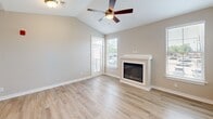 Located in D'Iberville, Mississippi, this two-story home offers a thoughtfully designed layout across two levels. The ground floor features an attached garage with an automatic opener, a hallway entry with wood-look flooring, and a staircase leading to the main living area above.

The upper level hosts the primary living spaces, beginning with an open-concept kitchen and living room. The kitchen is equipped with stainless steel appliances, white cabinetry, a central island with a sink and pendant lighting, and light wood-look flooring. The adjacent living room features vaulted ceilings, a ceiling fan, a fireplace with a white surround, and a door providing access to a balcony with outdoor views.

Both bedrooms are carpeted and include ceiling fans and dedicated closets fitted with wire shelving systems. The spacious primary bedroom offers a direct en-suite connection. Each of the two bathrooms is finished with light wood-look flooring, white vanities with solid countertops, and a tub-shower combination with brushed nickel fixtures. The neutral warm-beige color palette throughout the home creates a clean, cohesive aesthetic well-suited for comfortable everyday living.
