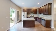 Located at 2214 Stallion Cir E in Toms River, NJ, this three-floor home offers a well-organized layout with thoughtfully designed spaces throughout. The kitchen is a standout feature, showcasing rich dark wood cabinetry reaching to the ceiling, granite countertops, a central island, and stainless steel appliances. A sliding glass door provides direct access to an outdoor deck, allowing natural light to pour into the space.

The bedrooms are carpeted and generously sized, with the primary bedroom featuring a tray ceiling and a spacious walk-in closet outfitted with custom dark wood shelving and hanging systems. Additional bedrooms include their own closets with built-in shelving, offering ample storage throughout.

The bathrooms are clean and well-appointed. The full bath includes a dark wood vanity with granite countertops and tile flooring, while a separate half bath features a pedestal sink and oval mirror. A dedicated laundry room with tile flooring, side-by-side washer and dryer, and overhead shelving adds everyday convenience.

The lower level includes a living area with hardwood-style flooring, sliding doors to the outdoors, and an attached garage with an automatic opener. The home's neutral palette and consistent finishes create a cohesive, move-in-ready atmosphere.