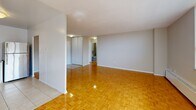Located at 165-195 Barrington Ave in Toronto's east end (M4C 4Z2), this one-bedroom, one-bathroom unit offers a well-organized, single-floor layout with a practical and functional design throughout.

The combined living and dining area is the heart of the unit, characterized by warm, classic parquet hardwood flooring that extends throughout the main living spaces. Large windows along the exterior wall flood the room with natural light and provide open views of the surrounding neighbourhood. Baseboard heating units run beneath the windows, ensuring year-round comfort.

The kitchen is accessed directly from the living area and is finished with light tile flooring, white cabinetry, granite-style countertops, and stainless steel appliances including a refrigerator and a gas range — offering a clean, functional cooking space.

The bedroom is a well-proportioned private retreat, also featuring parquet flooring, a window with natural light, and a closet with sliding doors for organized storage.

The bathroom is finished with neutral beige tile throughout, and includes a full soaking bathtub with a shower, complete with brushed nickel grab bars and fixtures — adding both practicality and a clean aesthetic.

Overall, the unit presents a bright, straightforward layout well-suited to comfortable urban living in Toronto.