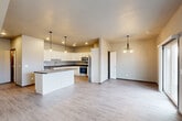 Located at 300 Devitt Dr in Harrisburg, South Dakota, this two-story home offers three bedrooms, four bathrooms, and a thoughtfully designed layout spread across two floors. The main level features an open-concept kitchen and living area unified by light-toned hardwood-style flooring. The kitchen is a standout, showcasing white shaker cabinetry, dark granite countertops, stainless steel appliances, a central island with pendant lighting, and recessed ceiling lights that create a bright, modern atmosphere. The living area flows seamlessly from the kitchen, providing a generous, versatile space. The upper level houses the bedrooms, including a spacious primary suite with vaulted ceilings and durable wood-style flooring. The bathrooms are clean and functional, featuring walk-in showers with brushed gold fixtures. Two dedicated laundry areas add significant convenience, one on each floor. Four closets throughout the home provide ample storage. The attached garage features a concrete floor and includes additional storage with double doors. Neutral tones, modern finishes, and a practical floor plan make this home a well-rounded and move-in ready residence.