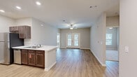 This single-floor residence in Central, SC offers a thoughtfully designed layout accommodating two bedrooms and two bathrooms. The open-concept kitchen and living area serves as the heart of the home, where light hardwood-style flooring, recessed lighting, and neutral gray walls create a clean, contemporary atmosphere. A ceiling fan anchors the living space, which extends toward French doors that provide access to an outdoor area and allow natural light to fill the room.

The kitchen is well-equipped with dark walnut-toned cabinetry, light marble-style countertops, stainless steel appliances including a refrigerator, range, microwave, and dishwasher, and a peninsula with a double sink that overlooks the living area—ideal for both cooking and entertaining.

The bedrooms feature plush carpet flooring and neutral tones, with windows providing natural light and outdoor views. The primary bedroom is generously proportioned and includes a walk-in closet outfitted with wire shelving systems for organized storage. The bathrooms are finished with hardwood-style flooring, dark cabinetry, and include a tub-shower combination with grab bars. A dedicated laundry room with washer and dryer hookups completes the functional layout.