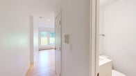 Studio D at 1550 Eustis Street offers a thoughtfully designed, efficiently laid-out studio in Saint Paul, MN. The space features light-toned hardwood flooring throughout the main living area, contributing to a bright and clean aesthetic complemented by crisp white walls and recessed lighting.

The compact kitchenette is neatly tucked into an alcove and is well-equipped with white cabinetry, stainless steel appliances including a refrigerator, dishwasher, built-in microwave, and a single-basin sink — providing all essential cooking and storage needs within a minimal footprint.

The main living area is open and versatile, benefiting from a window that invites natural light and frames a view of the surrounding greenery. A wall-mounted mini-split air conditioning unit and baseboard heating ensure year-round comfort, while recessed ceiling lights keep the space feeling airy and well-lit.

The bathroom is finished with neutral tile flooring, a white vanity with under-cabinet storage, a toilet, and a glass-door shower stall — clean and functional in design. Throughout the unit, the consistent use of white tones and natural wood creates a cohesive, modern, and minimalist ambiance ideal for a single occupant seeking a streamlined living environment in Saint Paul.