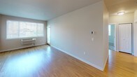 Located at 660 Columbia Point Dr in Richland, Washington, this single-floor residence offers a clean, modern aesthetic throughout. The open living area features warm hardwood-style flooring that reflects natural light streaming in through large windows, creating a bright and welcoming atmosphere. A private entry door leads into the spacious main living space, which flows seamlessly toward the kitchen.

The kitchen is well-equipped with stainless steel appliances, including a refrigerator, electric range, and over-the-range microwave. White cabinetry with ample storage lines the walls, complemented by light countertops and a stainless steel sink. Track lighting overhead ensures excellent task illumination throughout the cooking space. A peninsula provides additional prep space and separates the kitchen from the living area.

The bedroom is generously sized, featuring plush wall-to-wall carpeting and a ceiling fan for year-round comfort. Large windows fitted with blinds invite natural light while offering privacy, and views of the surrounding greenery and neighborhood are visible from multiple vantage points.

The overall design emphasizes a neutral color palette of soft whites and warm grays, clean lines, and functional layouts, making the space feel open, airy, and move-in ready.
