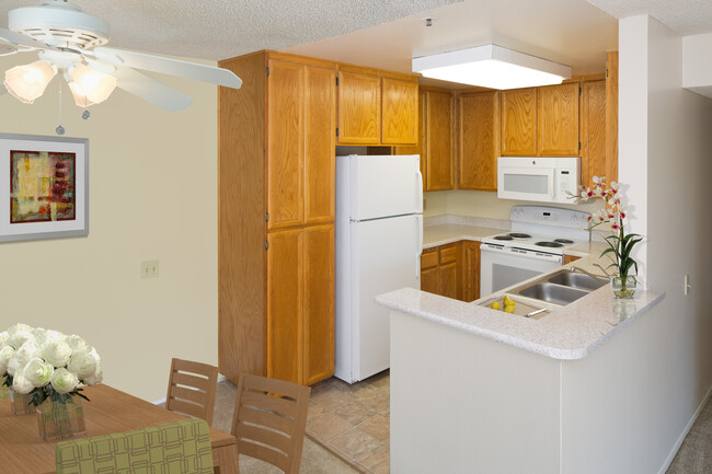 Cocina de paquete clásico con gabinetes de roble, encimeras laminadas moteadas de color beige, pisos cerámicos y electrodomésticos blancos. - eaves La Mesa