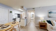 Located at 221 Plus Park Boulevard in Nashville, TN, this one-bedroom, one-bathroom unit offers a well-organized, single-floor layout that maximizes every square foot. The open-concept living, dining, and kitchen area forms the heart of the home, finished with light wood-style flooring and soft gray walls throughout. The living room is bright and welcoming, highlighted by a set of French doors that fill the space with natural light and provide a private outdoor entrance. The galley-style kitchen is efficiently designed with crisp white cabinetry, granite-style countertops, a subway tile backsplash, and a full suite of stainless steel appliances, including a refrigerator, electric range, and microwave. A peninsula counter connects the kitchen to the dining area, which features wainscoting details and a spacious closet. The bedroom offers comfortable carpet flooring, a natural light-admitting window, and a well-proportioned layout. The bathroom is cleanly finished with a granite-top vanity, white cabinetry, and wood-style flooring. A dedicated in-unit laundry area with a full-size washer and dryer adds everyday convenience. A hallway connects all rooms cohesively, completing this thoughtfully designed Nashville residence.