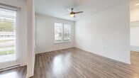 Located at 811 Rosery Rd NW in Largo, FL, this well-appointed single-story home offers three bedrooms and three full bathrooms within a thoughtfully designed open floor plan. The kitchen serves as the heart of the home, showcasing granite countertops, a large center island with a stainless steel sink, gray shaker-style cabinetry, a subway tile backsplash, and a full suite of stainless steel appliances including a refrigerator, range, microwave, and dishwasher. The kitchen flows seamlessly into the dining and living areas, creating an inviting, connected space filled with natural light from large windows. Wood-look flooring runs throughout the home, lending a warm and cohesive aesthetic. The generously sized primary bedroom features a ceiling fan, ample natural light, and a dedicated closet with built-in wire shelving, alongside an en-suite bathroom with a granite vanity and tiled shower. The additional bedrooms are bright and well-proportioned, each with windows overlooking the outdoors. All three bathrooms are finished with granite countertops, gray cabinetry, and wood-look flooring. Three closets and a utility room provide practical storage throughout. The clean, neutral palette and modern finishes create a fresh and comfortable living environment.