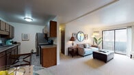 Located at 2507 Chestnut Hills Dr in Kalamazoo, Michigan, this single-floor residence offers a well-organized and comfortable layout designed for everyday living. The open-concept living area is carpeted and filled with natural light from a large sliding glass door that leads to a private balcony, providing pleasant outdoor views. The living room comfortably accommodates a seating arrangement and flows seamlessly into the dining area, which features a ceiling fan and is positioned adjacent to the kitchen. The galley-style kitchen is efficiently designed with warm wood cabinetry, laminate countertops, a double sink, and stainless steel appliances including a refrigerator and electric range, all set over easy-care vinyl plank flooring. The bedroom is a quiet, carpeted retreat with a window offering natural light and outdoor views. Two bathrooms serve the unit, each featuring white shaker-style vanities with stone countertops, undermount sinks, and wood-look vinyl plank flooring, giving them a clean, updated aesthetic. One bathroom includes a tub/shower combination. Throughout the residence, neutral wall tones and consistent finishes create a cohesive and inviting atmosphere suitable for a range of lifestyles.