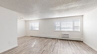 Located at 291 W Belleview Ave in Englewood, Colorado, this two-bedroom, one-bathroom residence offers a thoughtfully arranged single-floor layout with modern updates throughout. Light gray luxury vinyl plank flooring flows seamlessly through the living areas and bedrooms, complemented by crisp white walls and textured ceilings that give the space a clean, refreshed look. The living area is generously proportioned, featuring multiple windows dressed with white blinds that invite abundant natural light, along with a wall-mounted A/C unit and baseboard heating for year-round comfort. The kitchen is well-appointed with white shaker-style cabinetry, gray countertops, a stainless steel sink, and a stainless steel range with range hood, offering a functional and attractive cooking space. The spacious primary bedroom provides ample room and includes natural light from a window, baseboard heating, and closet access. The second bedroom is equally bright and comfortable, also featuring a window and baseboard heating. Three closets throughout the unit offer notable storage capacity. The full bathroom includes a tiled tub/shower combo, a window for natural ventilation, and brushed nickel fixtures. The overall ambiance is bright, neutral, and move-in ready, reflecting a clean and practical design aesthetic.