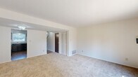 Located at 1301 N Whitcomb Ave in Indianapolis, Indiana, this two-story home offers three bedrooms and two bathrooms thoughtfully distributed across two well-proportioned floors. The main level features a bright living room with plush carpeting and a sliding glass door that opens to a fenced backyard, filling the space with natural light and providing easy outdoor access. The kitchen is equipped with dark espresso cabinetry, light granite-style countertops, a stainless steel sink, and wood-look flooring, complemented by a window that allows natural light to brighten the workspace. A hallway on the main floor connects key living areas, with wood-look flooring and a carpeted staircase leading to the upper level. Upstairs, the generously sized primary bedroom features carpeting, a large closet with louvered bifold doors and built-in shelving, and a window overlooking the exterior. The two additional bedrooms are also carpeted and offer comfortable proportions with closet access. The two bathrooms include one with a full tub-shower combination featuring classic white tile surround, and a second bathroom with a dark vanity and granite-style countertop. A dedicated closet provides extra storage, rounding out this practical and well-laid-out Indianapolis home.
