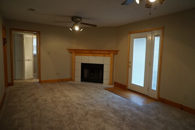 Den with fireplace, new carpet, and 2 ceiling fans. Great for entertaining guests. - 818 Stillwater Dr
