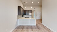 Located at 70 Church St in Flemington, NJ, this thoughtfully designed 2-bedroom, 1-bathroom unit offers a clean, modern aesthetic across a single floor. Light-toned hardwood flooring runs throughout, complemented by neutral walls and crisp white trim with matte black hardware accents that lend a contemporary edge.

The open-concept kitchen and living room serves as the heart of the home. The kitchen stands out with soaring ceilings, dark espresso cabinetry, a light quartz peninsula with an undermount sink, stainless steel appliances, tile backsplash, and stylish pendant lighting — ideal for both everyday living and entertaining. A separate dining room provides additional flexibility for meals and gatherings.

A bright hallway connects the living spaces to the private quarters. Both bedrooms feature the same warm flooring, tall ceilings, and soft neutral tones. The primary bedroom benefits from large windows that invite abundant natural light and views of the surrounding area, along with a double-door closet for generous storage. The second bedroom is similarly appointed with its own accent wall.

The bathroom is finished with a white vanity, quartz countertop, undermount sink, matte black faucet and fixtures, and a sleek framed mirror. A dedicated laundry area and two closets round out the practical amenities of this well-appointed space.