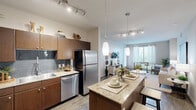 Located in Austin's Domain area, this well-appointed 2-bedroom, 2-bathroom residence offers a thoughtfully designed open-concept layout across a single floor. The kitchen is a standout, featuring rich dark-wood cabinetry, granite countertops, a tile backsplash, stainless steel appliances including a refrigerator, dishwasher, and range, and a central island with pendant lighting that doubles as a casual dining space. The kitchen flows seamlessly into the living room, which is bright and airy thanks to large windows that invite natural light. The living area features wood-style flooring and provides generous space for both lounging and entertaining. The primary bedroom offers plush carpeting, a ceiling fan, and natural light from large windows, complemented by a spacious walk-in closet with built-in shelving and hanging rods. The second bedroom is equally comfortable with similar finishes. Both bathrooms are finished with granite-topped vanities, dark wood cabinetry, and tile-surround tub-shower combinations. Wood-style flooring carries through the bathrooms, adding a cohesive aesthetic. The layout also includes a hallway connecting the rooms efficiently, rounding out a functional and modern living space.