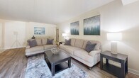 This well-appointed 2-bedroom, 2-bathroom single-floor residence in Towson, Maryland offers a thoughtfully designed layout with a comfortable, neutral aesthetic throughout. The living room is bright and inviting, featuring wood-style flooring, warm neutral walls, and a sliding door that brings in natural light. It flows naturally into a dedicated dining area, distinguished by a decorative vertical-paneled accent wall and overhead flush lighting, creating a refined space for everyday meals or entertaining. The galley-style kitchen is outfitted with light maple cabinetry, granite-look countertops, a stainless steel sink, and a full suite of stainless steel appliances, with a direct pass-through view into the dining room. The spacious primary bedroom comfortably accommodates large furniture, offers a window for natural light, and includes a walk-in closet with built-in shelving and hanging rods. The second bedroom is similarly well-sized with its own window. Both bathrooms feature tub-shower combinations and clean, classic finishes. Wood-style flooring runs throughout the main living areas, tying the home together with a cohesive, modern feel. A hallway and dedicated closet provide additional storage and functionality across this efficiently planned residence.
