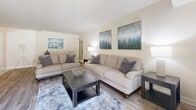 This well-appointed 2-bedroom, 2-bathroom single-floor residence in Towson, Maryland offers a thoughtfully designed layout with a comfortable, neutral aesthetic throughout. The living room is bright and inviting, featuring wood-style flooring, warm neutral walls, and a sliding door that brings in natural light. It flows naturally into a dedicated dining area, distinguished by a decorative vertical-paneled accent wall and overhead flush lighting, creating a refined space for everyday meals or entertaining. The galley-style kitchen is outfitted with light maple cabinetry, granite-look countertops, a stainless steel sink, and a full suite of stainless steel appliances, with a direct pass-through view into the dining room. The spacious primary bedroom comfortably accommodates large furniture, offers a window for natural light, and includes a walk-in closet with built-in shelving and hanging rods. The second bedroom is similarly well-sized with its own window. Both bathrooms feature tub-shower combinations and clean, classic finishes. Wood-style flooring runs throughout the main living areas, tying the home together with a cohesive, modern feel. A hallway and dedicated closet provide additional storage and functionality across this efficiently planned residence.