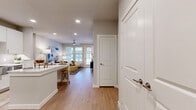 This single-story, 2-bedroom, 2-bathroom residence offers a thoughtfully designed open-concept layout that seamlessly connects the kitchen and living areas. The kitchen is a standout feature, equipped with crisp white shaker cabinetry, stainless steel appliances including a French door refrigerator and range, a subway tile backsplash, and a peninsula with seating — ideal for casual dining or entertaining. The living room is bright and welcoming, with a ceiling fan, large windows, and a glass door that invites natural light and provides access to the outdoors. Warm hardwood-style flooring runs throughout the entire residence, creating a cohesive and clean aesthetic. The primary bedroom is a comfortable retreat, supported by two walk-in closets with built-in shelving and hanging rods offering generous storage. The en-suite bathroom features a double vanity with white cabinetry, quartz countertops, and a large mirror. The second bedroom also benefits from natural light through dual windows and its own ceiling fan. Additional highlights include five closets total, a dedicated laundry area, and a neutral gray-toned color palette throughout. The layout is practical and efficient, making excellent use of the available floor space.