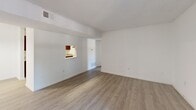 This well-appointed 2-bedroom, 2-bathroom single-floor residence at 1000 Windsor Shores Dr in Columbia, SC offers a functional and comfortable layout. The living room serves as the heart of the home, featuring wood-look flooring, a classic wood-burning fireplace with a white mantle, and a sliding glass door that opens to a private balcony with outdoor views. A pass-through window connects the living area to the kitchen, which is outfitted with dark espresso cabinetry, granite countertops, stainless steel appliances including a full-size refrigerator, and a pendant light fixture over the adjoining dining area. Both bedrooms are carpeted and include ceiling fans, natural light from large windows with views of surrounding greenery, and generous closet space. The primary bedroom features built-in upper cabinetry and a bifold closet door. Both bathrooms are finished consistently with dark wood vanities, granite countertop sinks, large mirrors, and updated light fixtures over wood-look tile flooring. The home also includes a dedicated utility room and a closet for additional storage, rounding out a practical and cohesive living space.