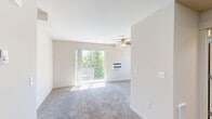 Located at 1090 N Cecil Rd in Post Falls, Idaho, this efficiently designed studio unit offers a well-utilized single-floor layout that maximizes every square foot of its compact footprint. The main living area features warm neutral-toned carpet, a ceiling fan with light fixture, a wall-mounted HVAC unit, and a sliding glass door that opens to a private balcony overlooking lush greenery. A secondary window allows additional natural light to fill the space, creating a bright and airy atmosphere. The kitchen is thoughtfully appointed with rich dark-wood cabinetry, light countertops, wood-look vinyl flooring, and a full suite of black appliances including a range, over-the-range microwave, refrigerator, and a double-basin sink. Ample upper and lower cabinet storage makes the kitchen both functional and organized. The bathroom continues the cohesive design with matching dark-wood cabinetry, a large vanity mirror, light stone-style countertops, wood-look vinyl flooring, and a shower stall. The overall aesthetic throughout the unit is clean and consistent, with neutral walls and modern finishes that create a move-in-ready environment well-suited for comfortable everyday living.